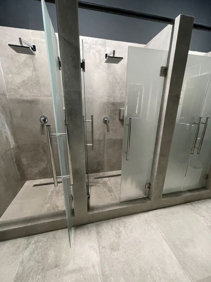 Boxes de chuveiro com portas de vidro no vestiário